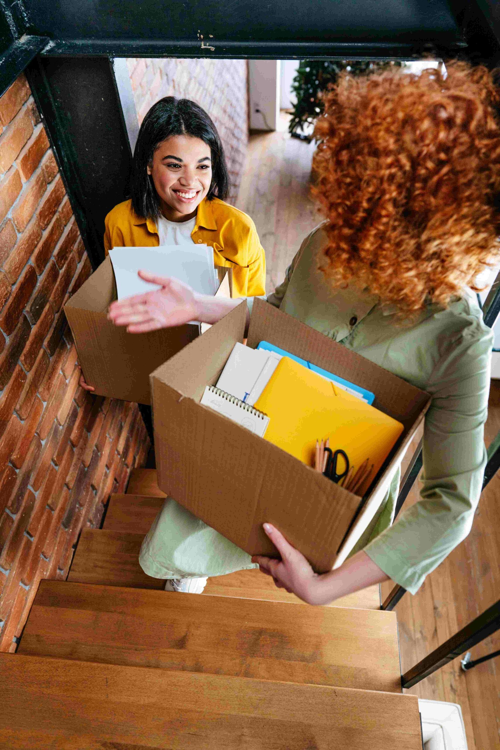 two young happy women moving to new office